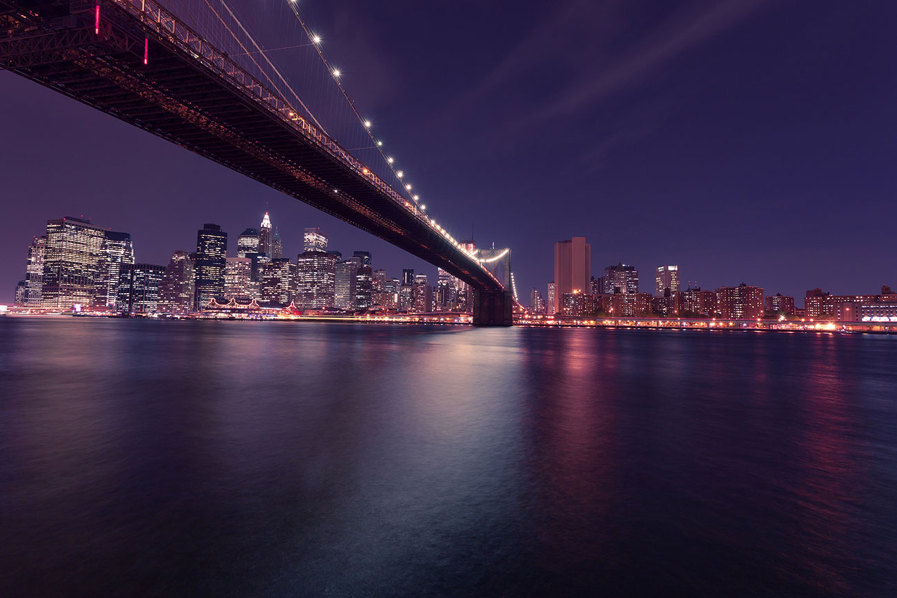 bridge over water with city in background