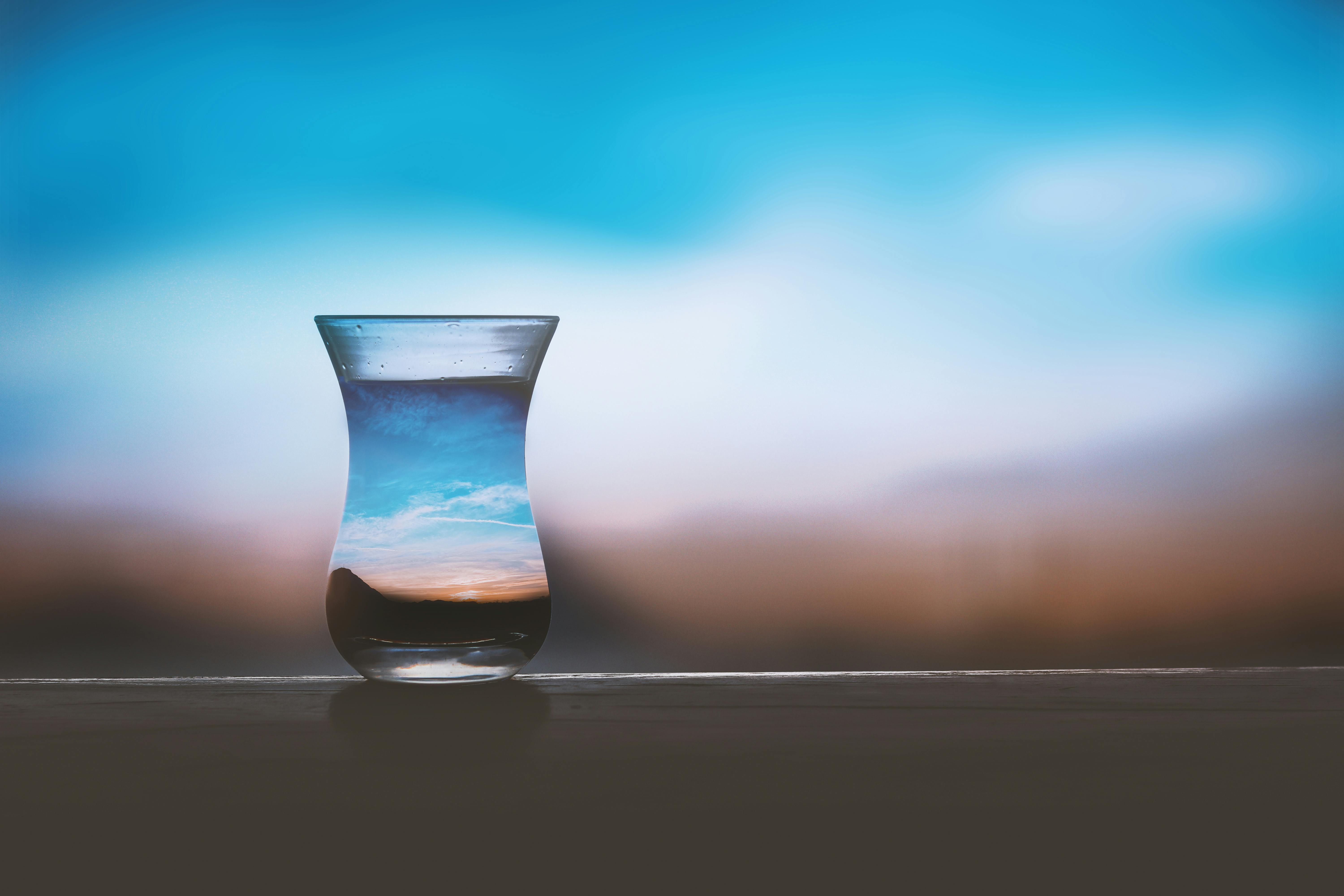 small water glass in front of blurred landscape